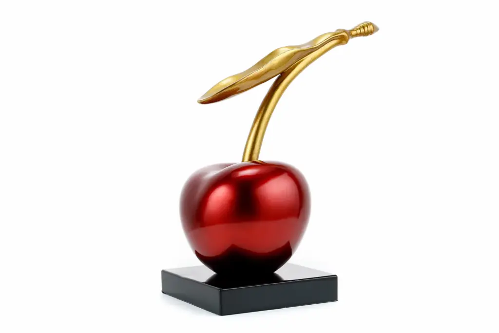 Moderne rote Kirschskulptur mit goldenem Stiel, glänzendes Dekorationsobjekt für die zeitgenössische Wohnkultur.